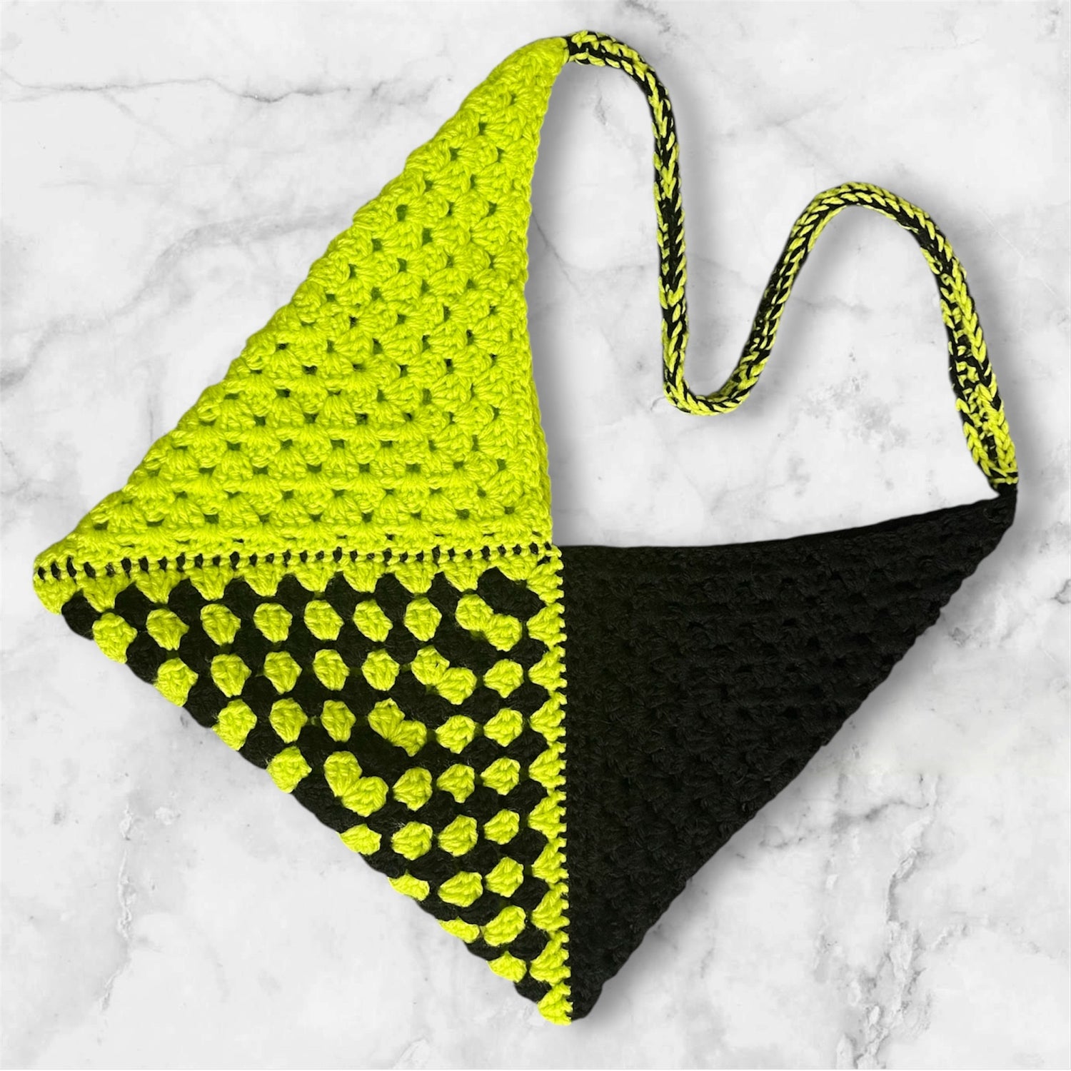 crochet granny tote bag in colors slime green and black yarn, on marble background